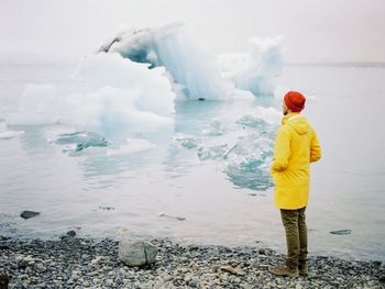 Man standing at sea shore during winter