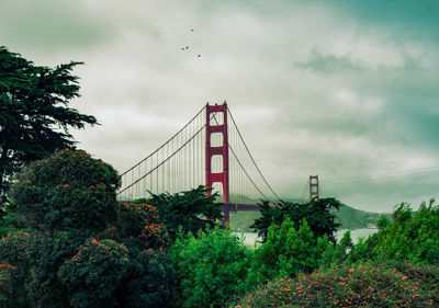 View of suspension bridge against cloudy sky