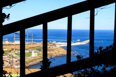 Scenic view of sea and cityscape seen through window