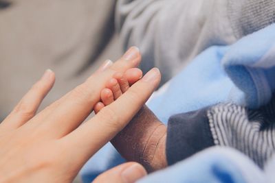 Close-up of mother holding newborn baby feet