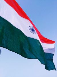 Low angle view of flag against clear blue sky