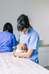 Midsection of veterinarian examining puppy