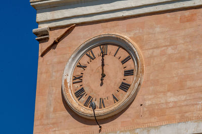 Low angle view of clock on building wall