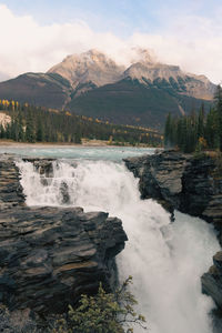 Scenic view of waterfall against sky