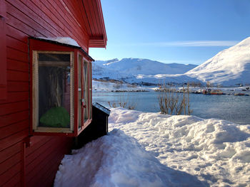 Scenic view of snow covered mountain against sky.  typical novwegian house 