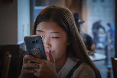 Young woman using mobile phone at home