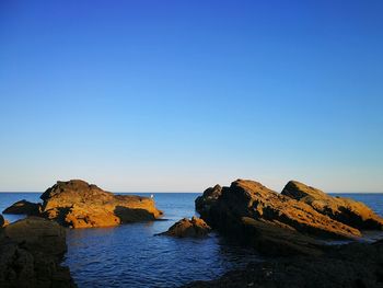 Scenic view of sea against clear blue sky