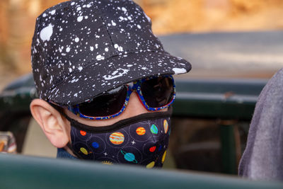 Close-up of boy with baseball csp and sunglasses