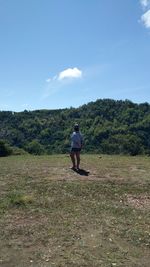 Man standing on field against sky