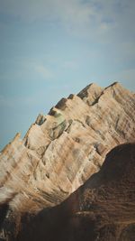 Rock formations on landscape against cloudy sky