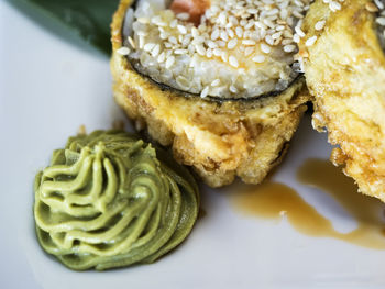 High angle view of sushi rolls with shrimp and chutney served in plate