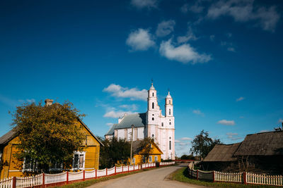 View of buildings and trees against blue sky