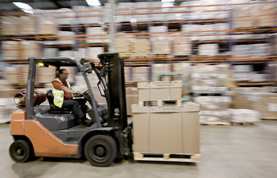 Forklift truck speeding through warehouse