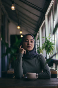 Portrait of young woman sitting in restaurant