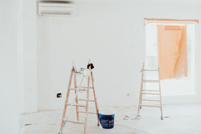 Ladders and pots on white room at construction site. painting walls. home improvement, renovation