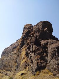 Low angle view of rock formation against clear sky