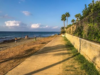 Footpath by sea against sky