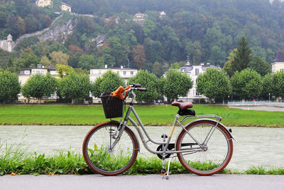 Travel to salzburg, austria. a bicycle on a view of a park, a river and mountains.