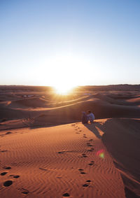 Scenic view of desert against clear sky during sunset