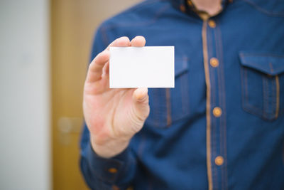 Close-up of hand holding paper with text