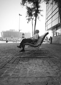 People sitting on footpath in city