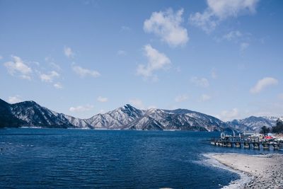 Scenic view of sea and mountains against sky