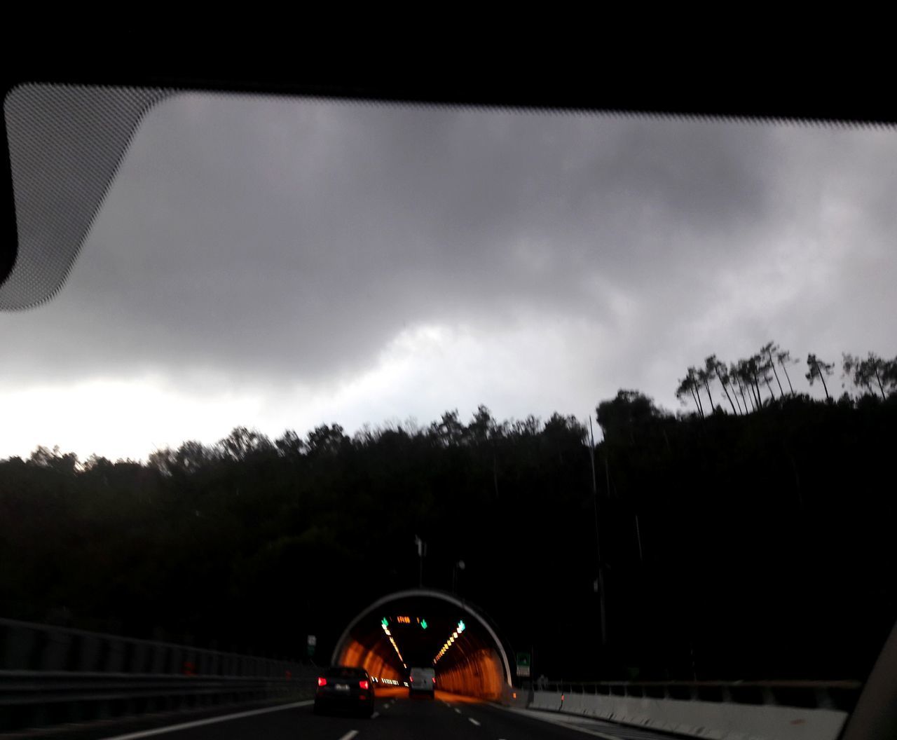 CAR MOVING ON ROAD AGAINST CLOUDY SKY