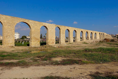 Low angle view of kamares aqueduct against blue sky