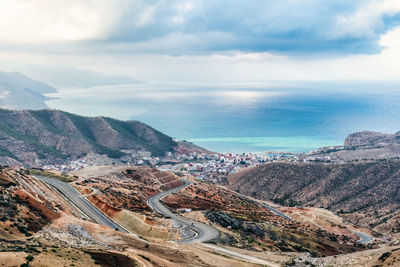 High angle view of sea and mountains against sky