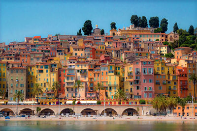 Colorful buildings at beach against clear blue sky during sunny day