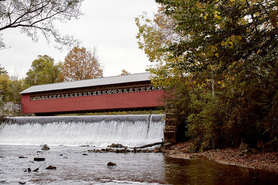 Built structure by river against sky