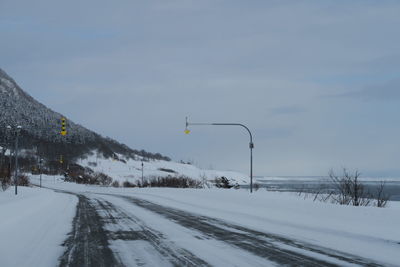 Snow covered road against sky