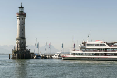 Lighthouse by sea against sky