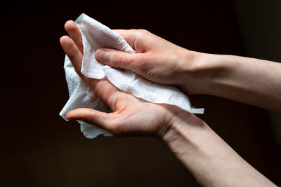 Close-up of woman holding hands over black background