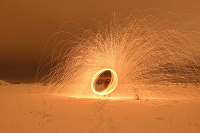 Man spinning wire wool on field during winter