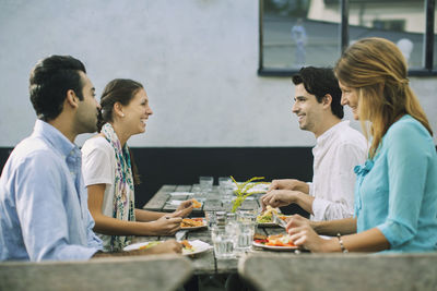 Happy couples at outdoor cafe having lunch