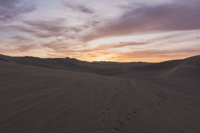 Scenic view of desert against sky during sunset