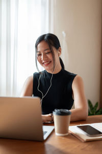 Young woman using laptop at home