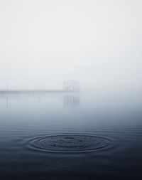 Scenic view of lake against sky during foggy weather