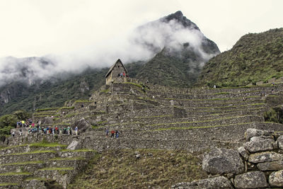 People on mountain against sky