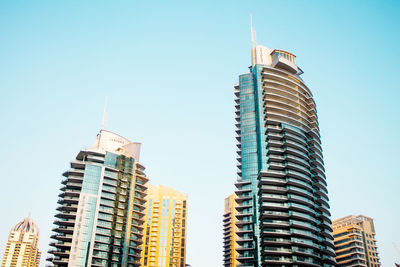 Low angle view of modern buildings against clear blue sky