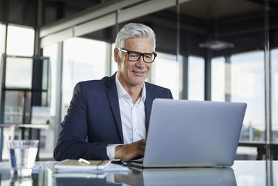 Businessman working in office, using laptop