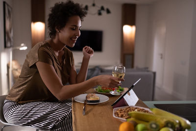 Black female proposing toast to online friends