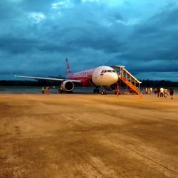 Airplane on airport runway against sky