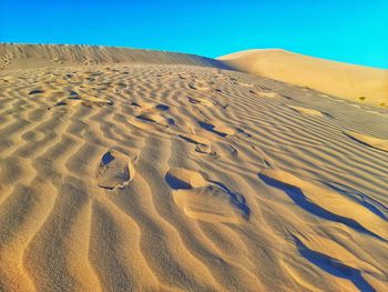 Sand dune in desert against clear blue sky