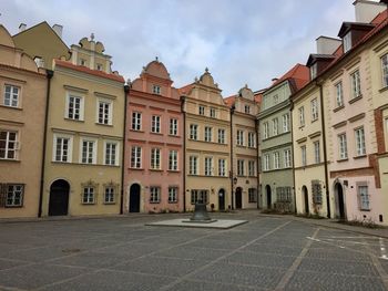 Street by buildings in town against sky