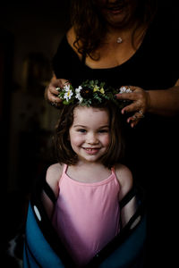 Aunt placing flower crown on niece's head