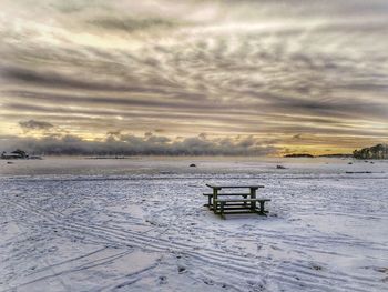 Pier on sea against cloudy sky