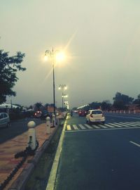 Cars on street in city against sky