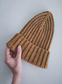 Close-up of hand holding bread against white background